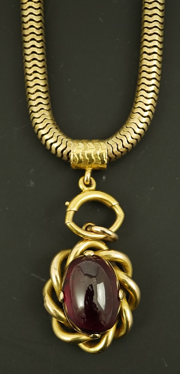 A Victorian gold snake link chain, hung with a gold and single stone oval cabochon garnet set mourning pendant